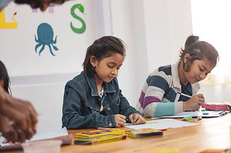 Children writing during their online lesson