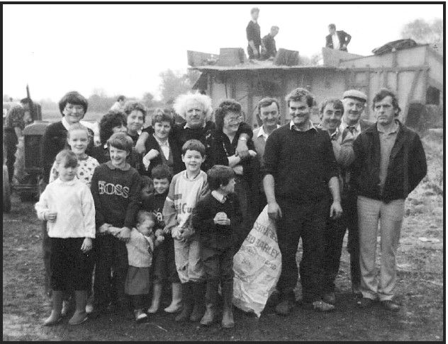 Joe Ahern (far right) with family and friends. Old threshing machine at rear.