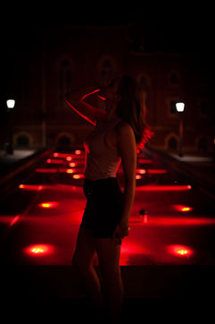 Young woman posing in front of a red fountain.