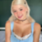 Kacy Klitty OnlyFans brown-haired woman pouts for the camera in a red dress and a flower on her hair.