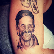 grayscale portrait tattoo of a man's head