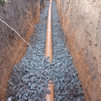 drainage pipe in an excavated trench with hardcore laid around for an installation in newport