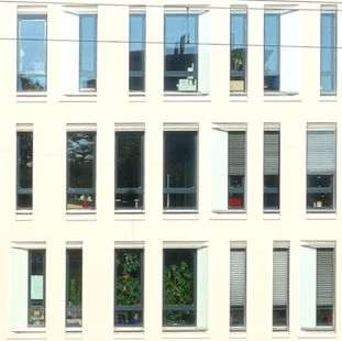 Fensteraufnahme des Merck Gebäudes in weiß  in Darmstadt mit hohen Fenstern. Entworfen von dem Architekten Johann Eisele. 