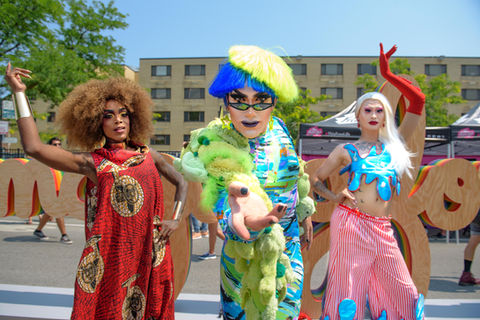 three drag queens pose for the pride parade
