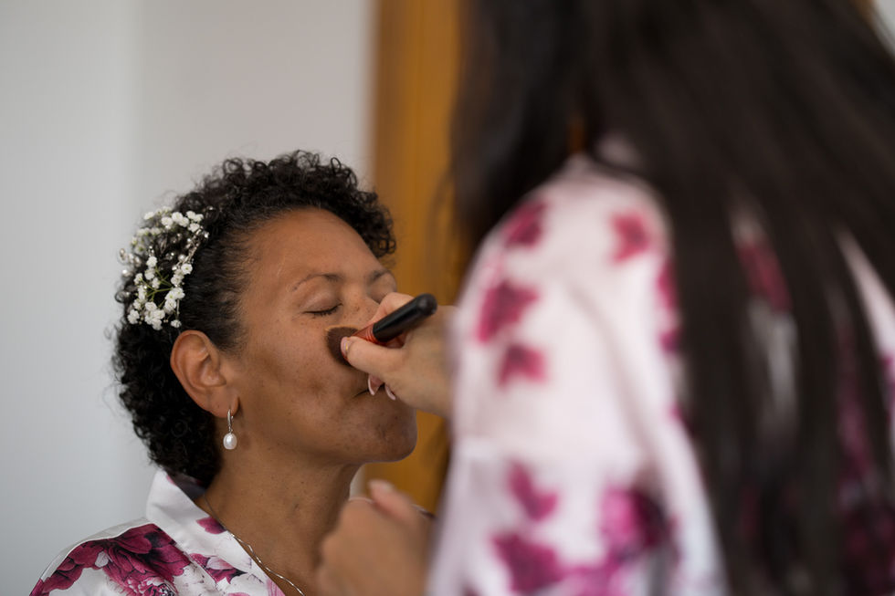 Bride getting professional makeup, elegant beaded headpiece, intimate preparation.