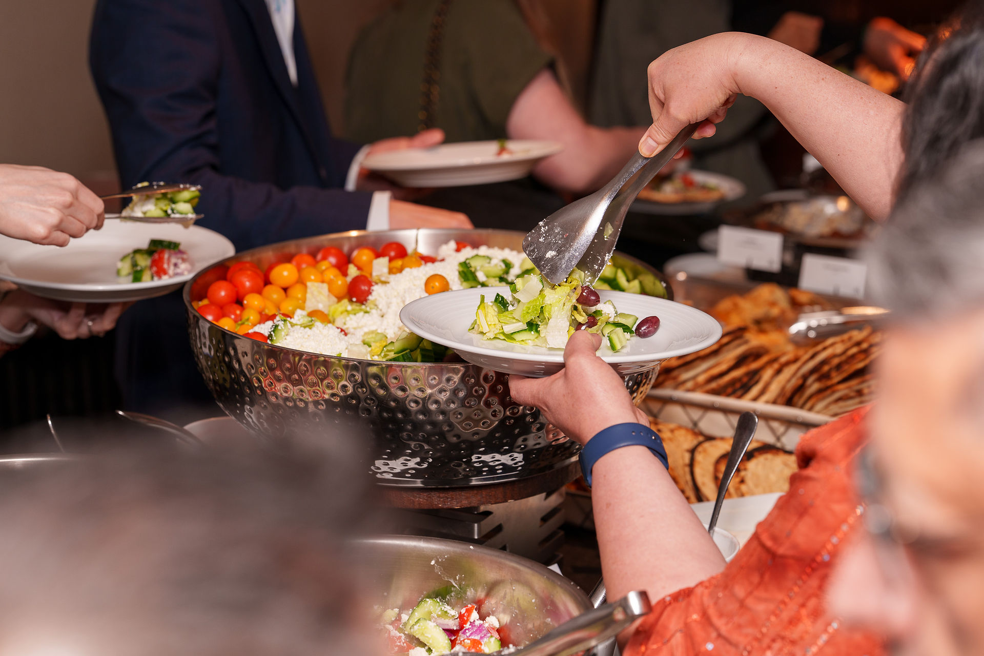 Guests serving food at a symposium buffet