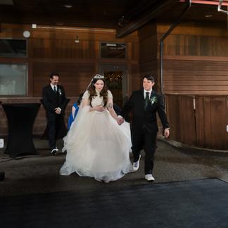 Bride and groom running hand-in-hand at their Gold Mountain Golf Club wedding.