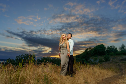 Couple embraces outdoors with a beautiful sunset in the background, portland wedding photographer