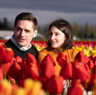 Couple smiling in red tulips at Skagit Tulip Festival