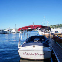 Boat named "Water, New Purpose" docked at marina