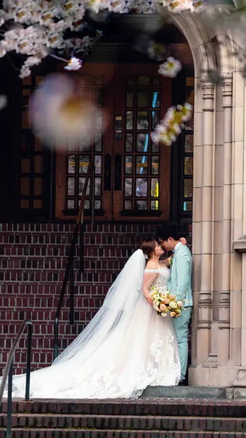 Bride and groom kissing, church stairs, flowers, wedding veil, portland wedding photographer