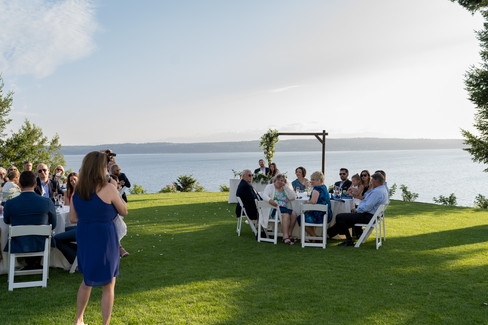 Wedding guests enjoying outdoor reception by water on Camano Island.