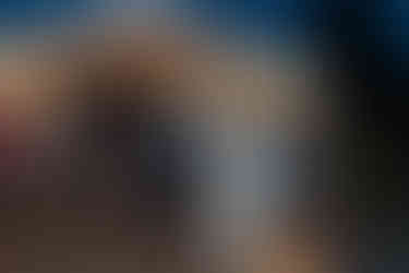 Happy couple dancing under a lit tent at intimate farm wedding.