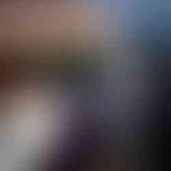 Bride and guests listen to speech under tent at intimate farm wedding.