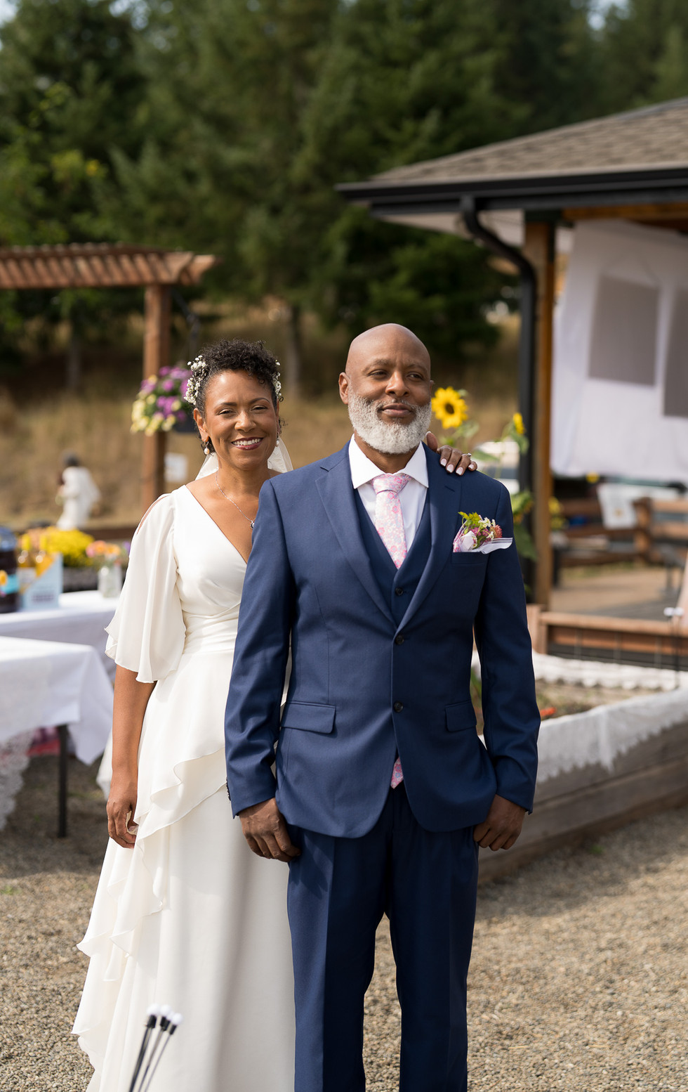 Smiling bride and groom posing at their intimate outdoor farm wedding.