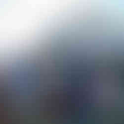 Two men in suits walking past seated guests at an intimate farm wedding.