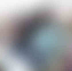 Black couple attentively watching an outdoor event from white chairs.