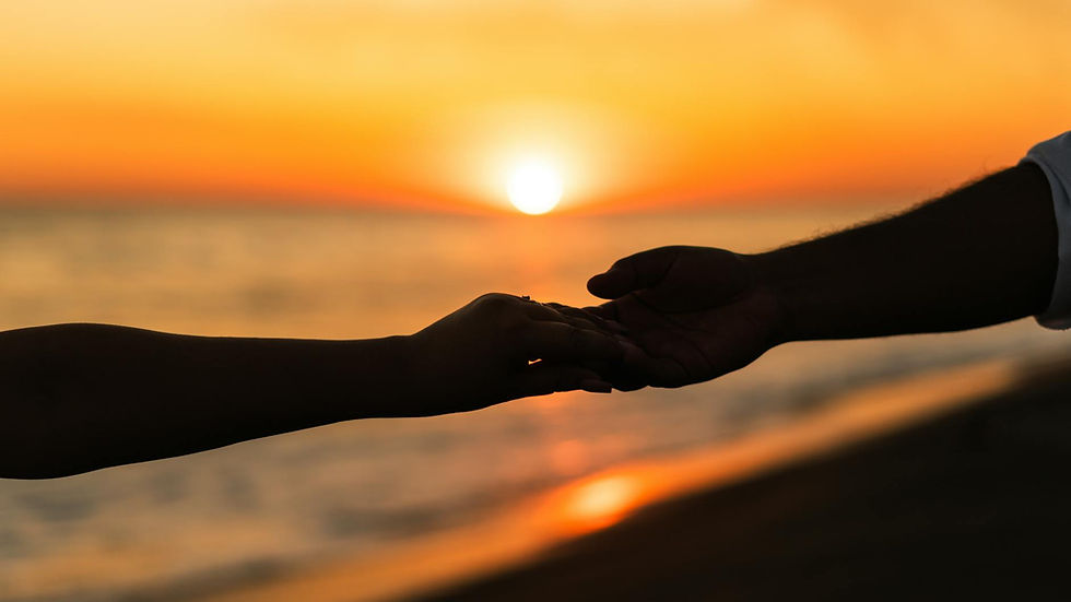 Silhouette of a couple holding hands during a romantic beach sunset.