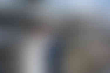 Happy couple holding hands, gazing lovingly at their farm wedding.