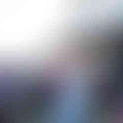 Woman in blue dress holding flowers at intimate outdoor farm wedding.