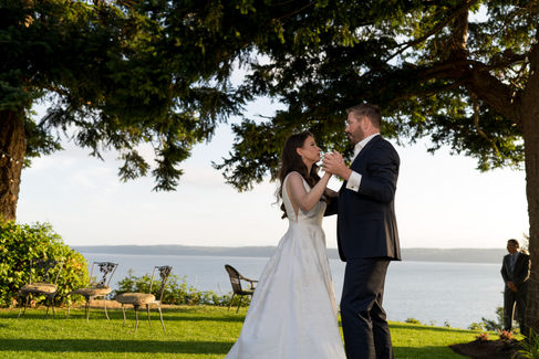 Bride and groom clinking glasses, serene waterfront wedding on Camano Island.