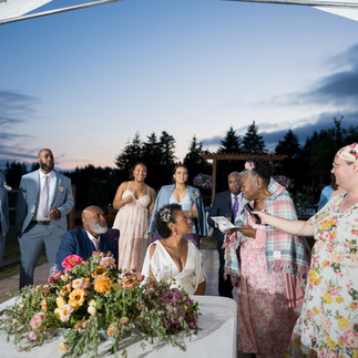 Bride and groom signing marriage documents at their outdoor evening ceremony.
