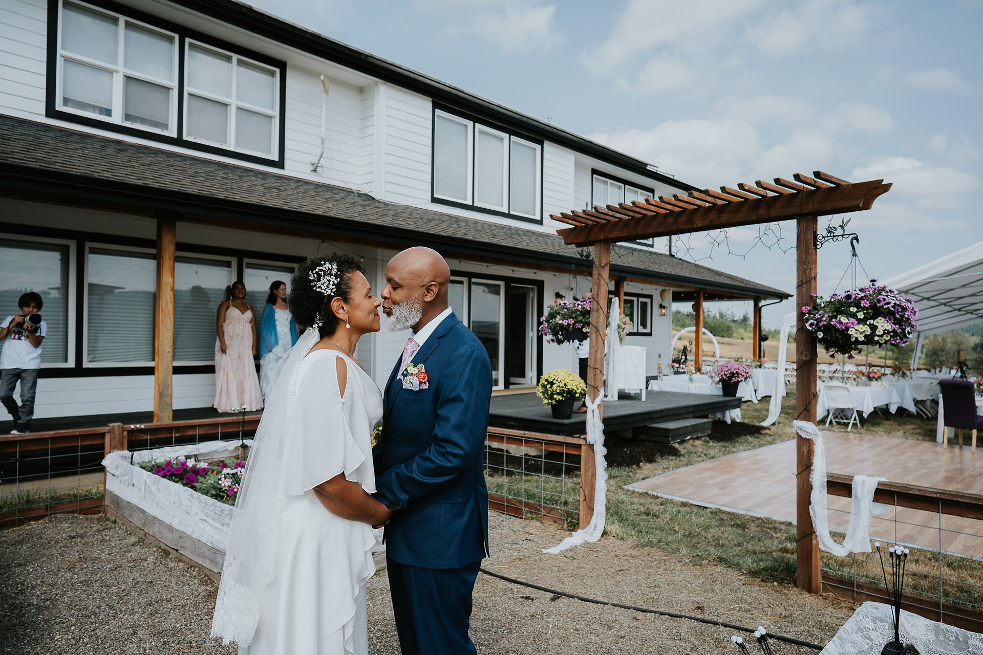 Newlywed bride and groom holding hands, gazing lovingly at their outdoor wedding.