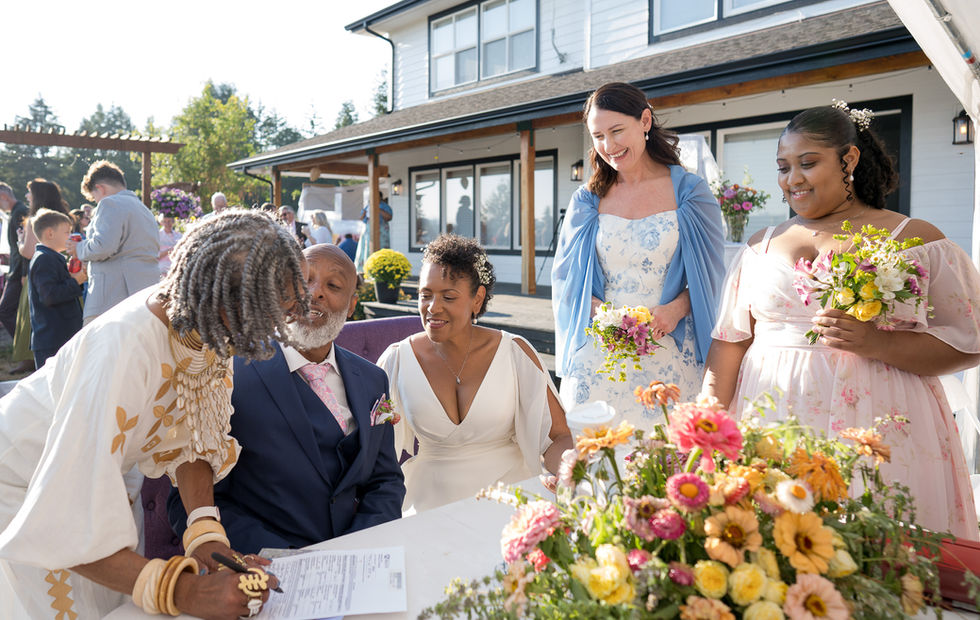 Happy couple signing marriage certificate at intimate farm wedding.