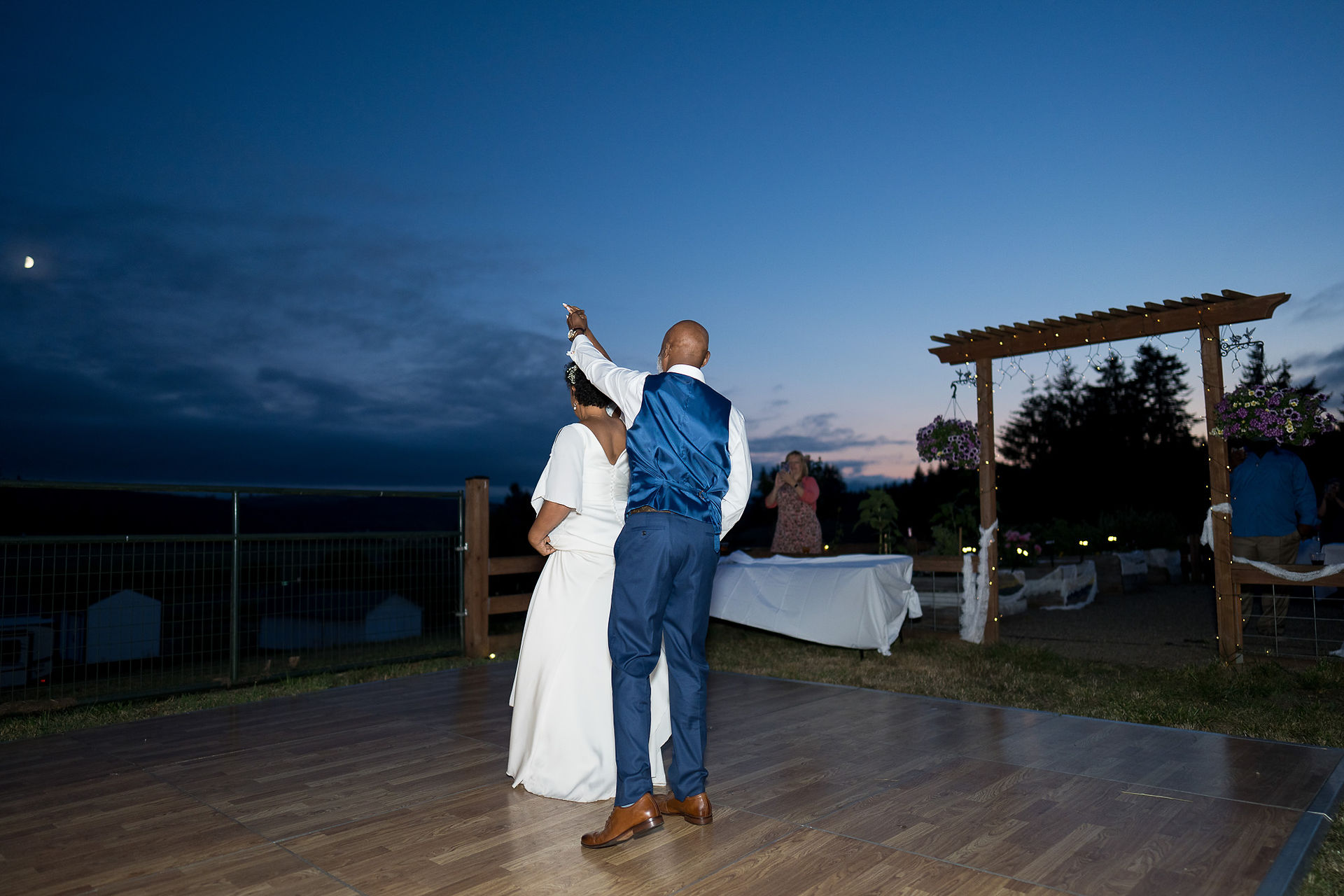 Bride and groom dancing outdoors at dusk during intimate farm wedding.