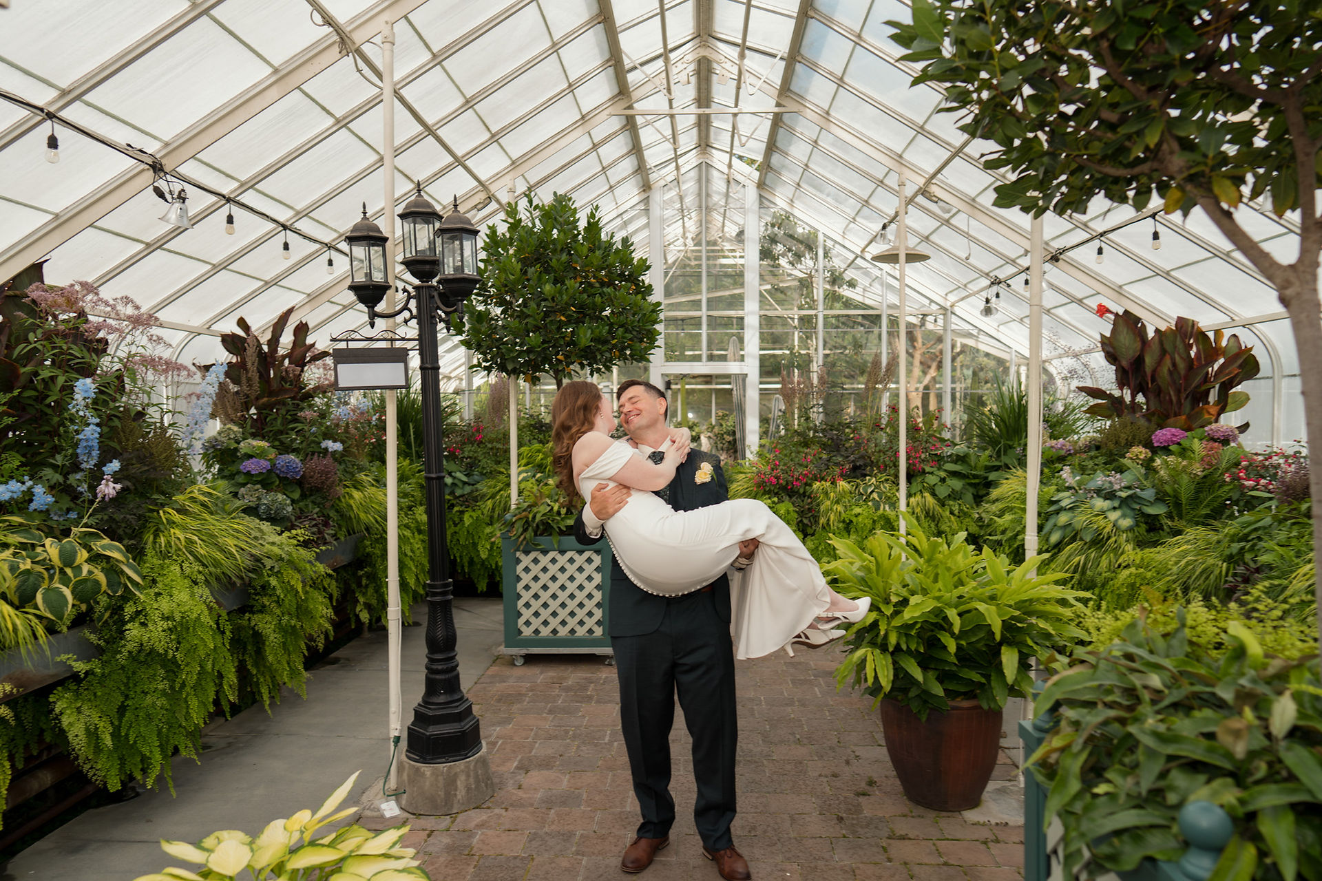 Groom carrying bride at Volunteer Park Conservatory in Seattle