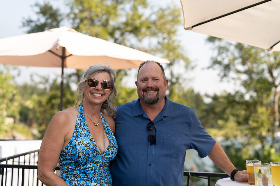 Happy man and woman smiling at an outdoor summer event.
