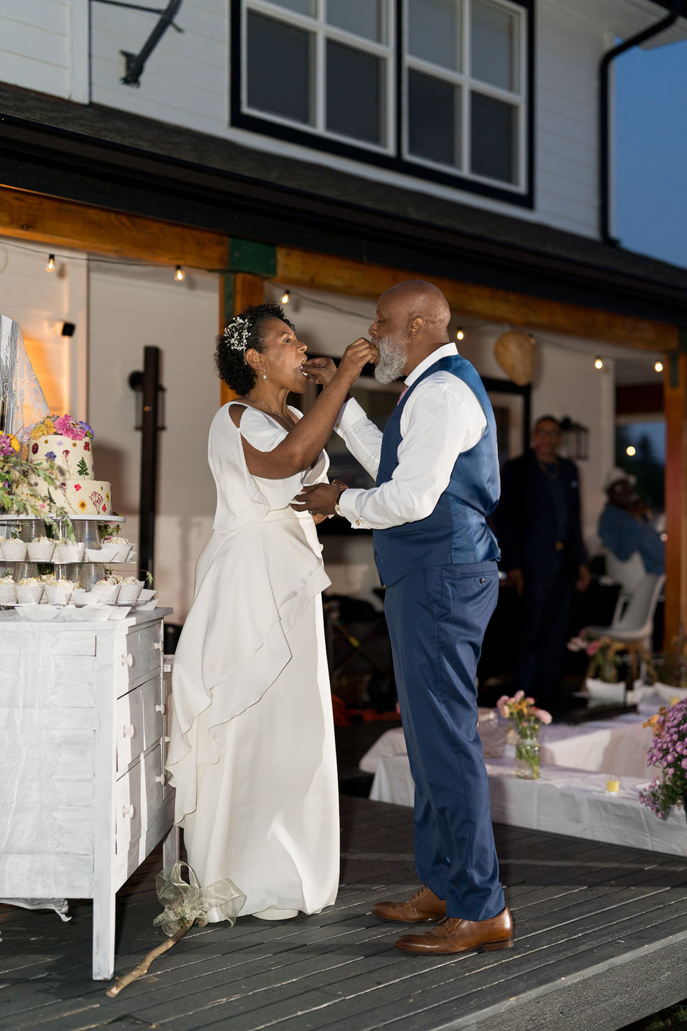 Bride feeding groom wedding cake at their intimate farm wedding.