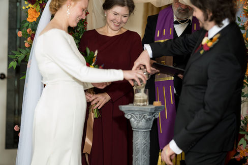 Smiling bride, groom perform unity sand ceremony at their wedding.