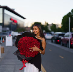 Woman holding a large bouquet of red roses