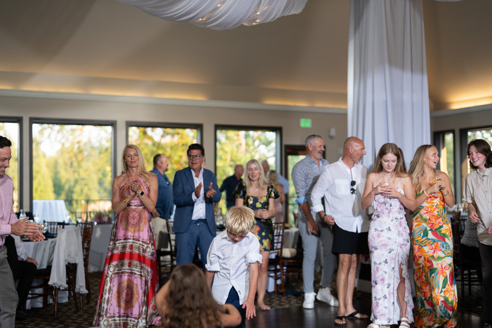 Attendees clap during a lively indoor event with a view.