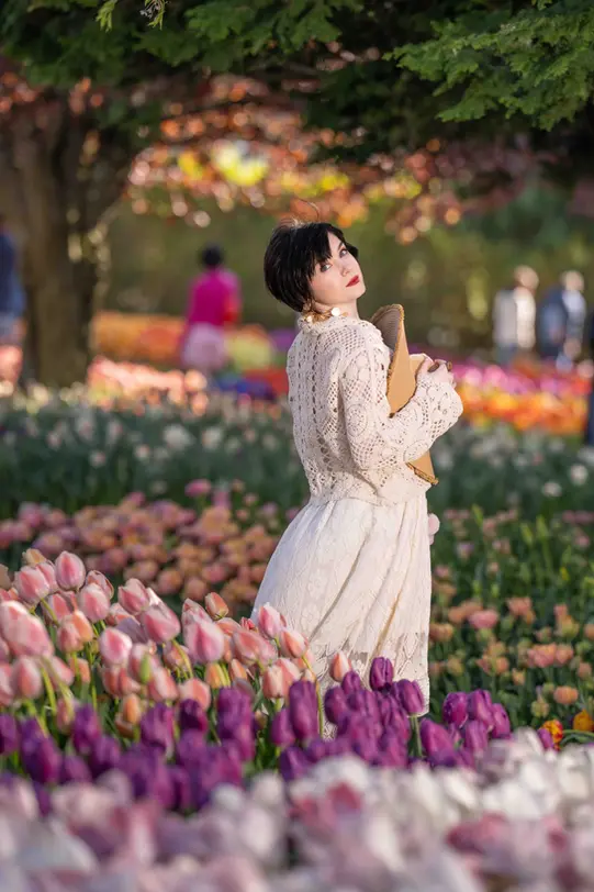 Woman in white dress amongst tulips