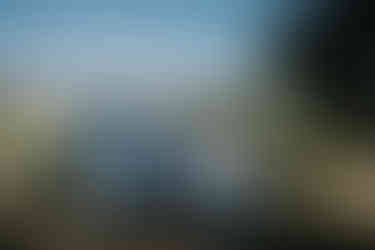 Five men in light blue and navy suits smiling outdoors.