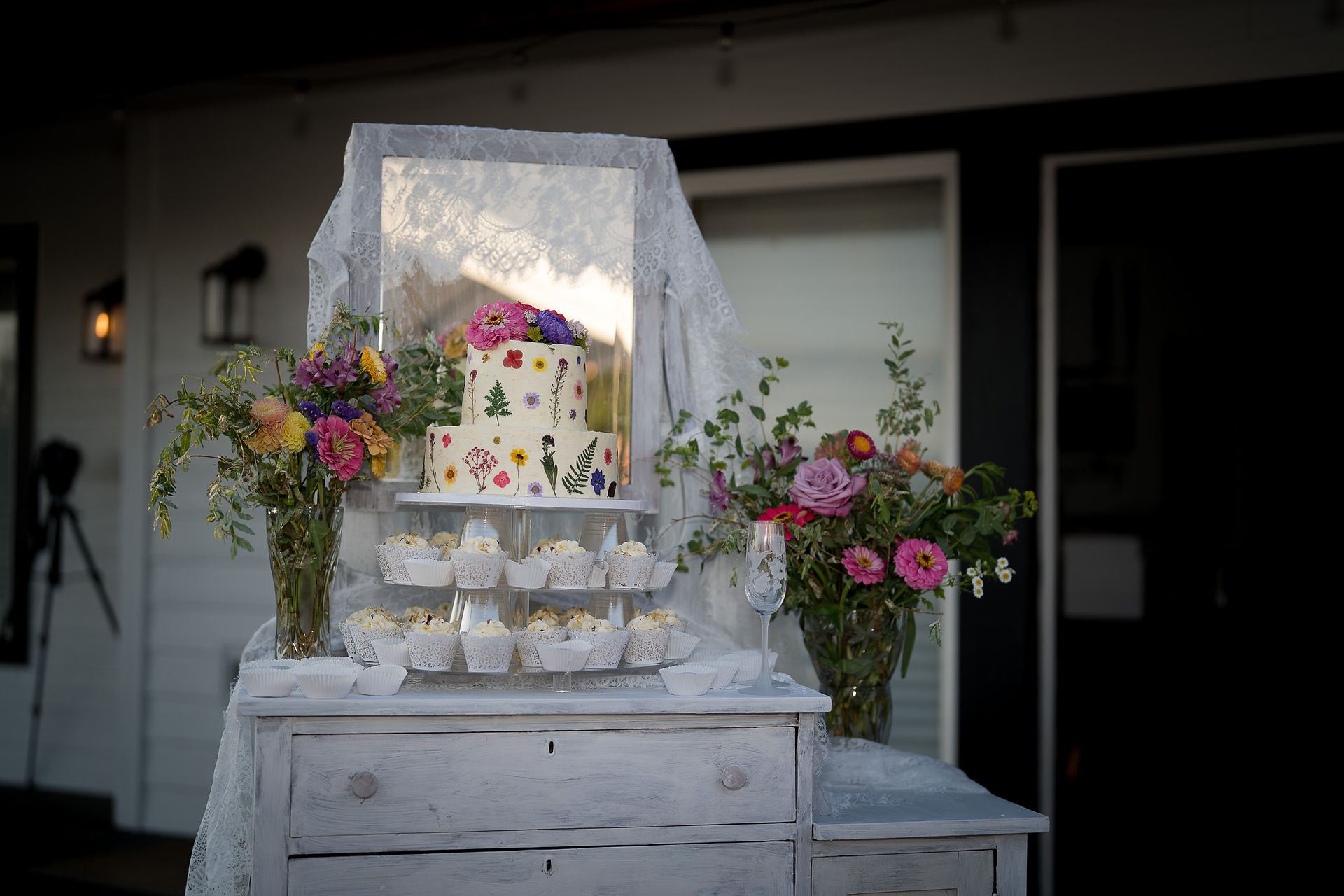 Two-tier wedding cake, cupcakes on rustic dresser for Intimate Farm Wedding.
