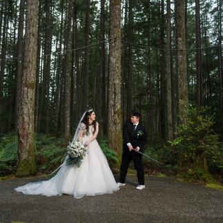 Wedding couple in a forest at Gold Mountain Golf Club, groom holding a sword
