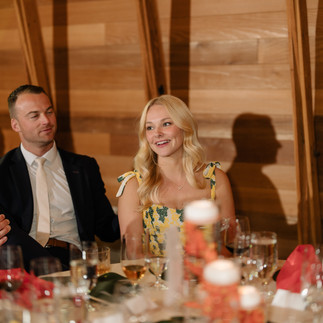Happy couple smiling at their wedding reception table.