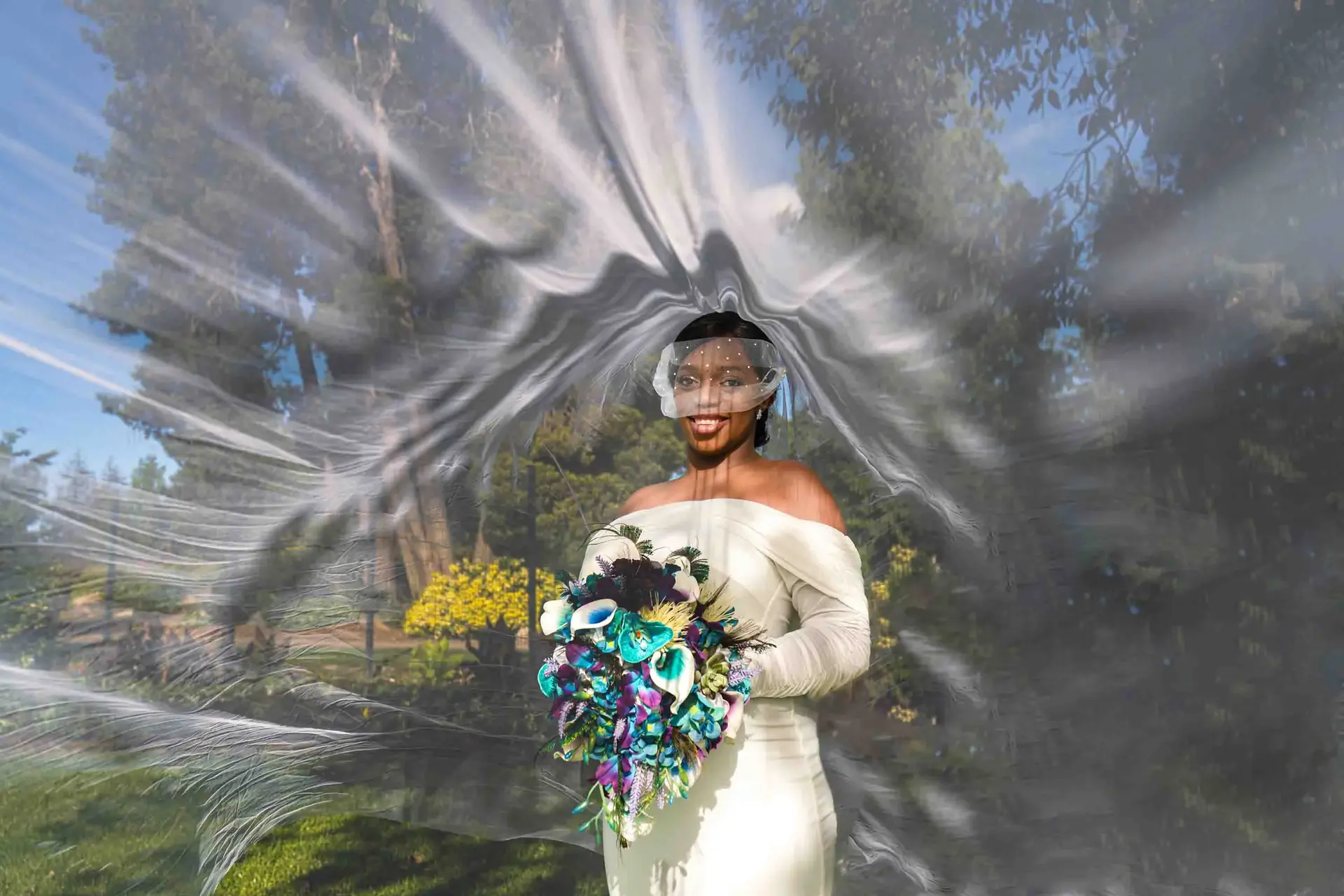 Bride in flowing veil, holding bouquet, outdoor garden setting