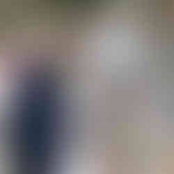 Man in suit serving food from outdoor wedding buffet table.