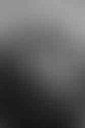 Bearded man and woman intently watching ceremony, she holds bouquet.