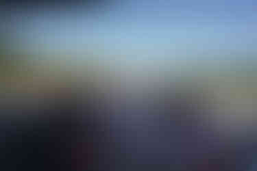 Outdoor wedding ceremony with guests watching in a sunny open field.