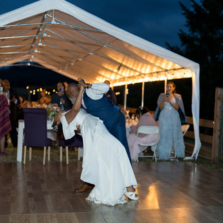 Bride and groom dance under a lighted tent at their wedding reception.