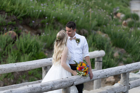 Bride and groom share a tender moment on a rustic bridge