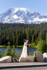 Couple at a Mount Rainier elopement by a lake and peaks.
