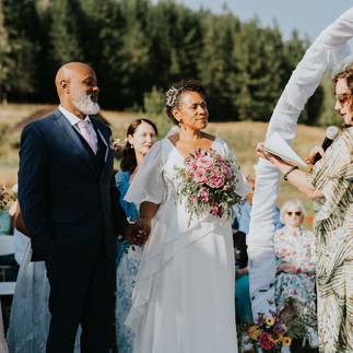 Bride and groom hold hands at their intimate outdoor wedding ceremony.