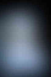 Rustic dresser with wedding cake, cupcakes, and colorful flowers outdoors.