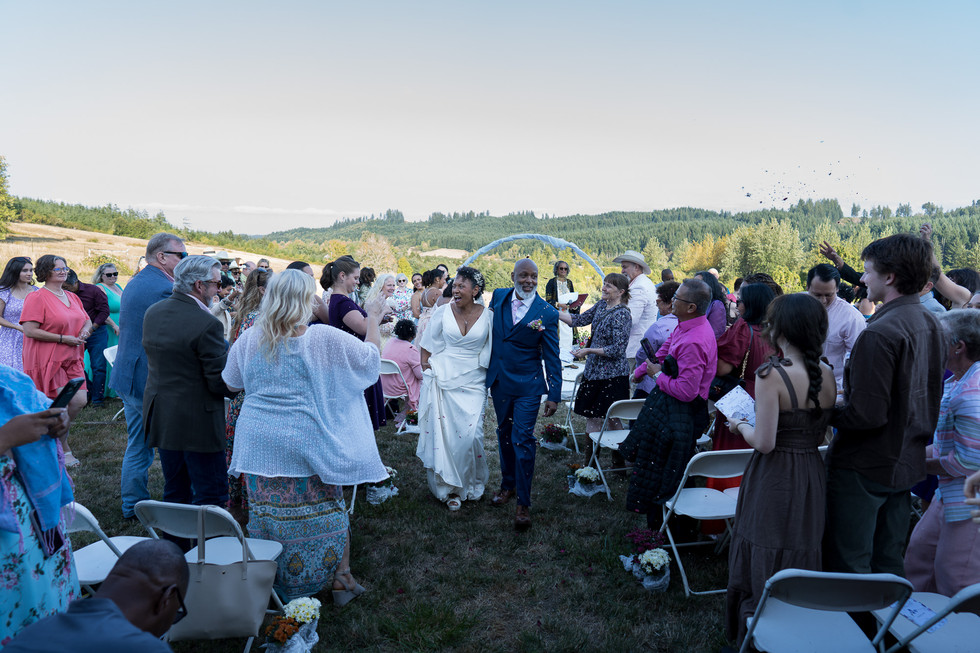 Happy couple walking down aisle at their intimate farm wedding.